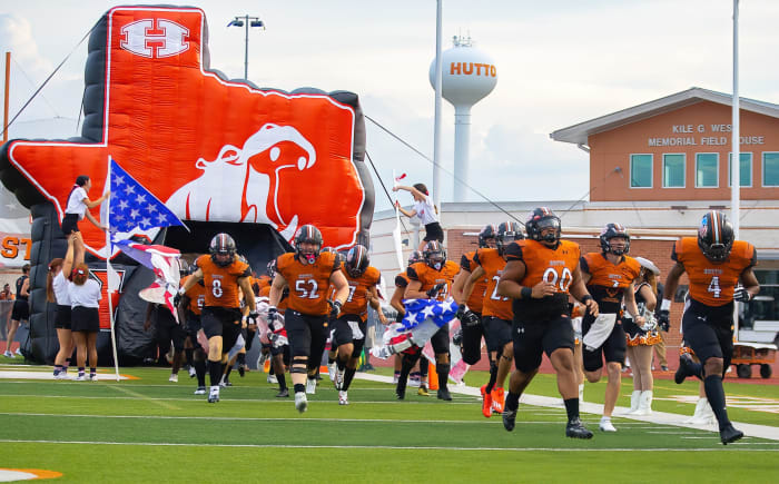 The Hutto football team crashes through a Texas-sized Hippo banner.